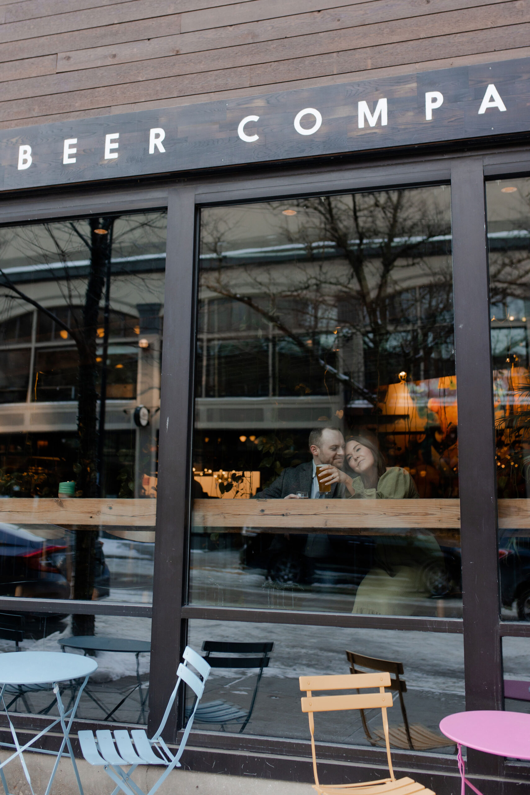 A couple in a suit + white dress take engagement photos at a brewery in Madison, WI by Claire Neville Photography 