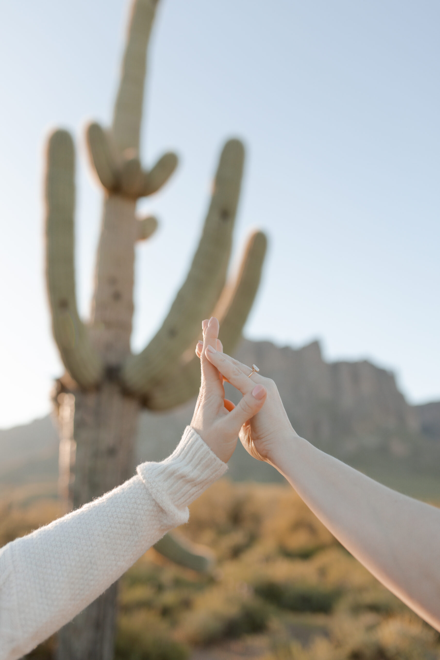 Two women pose in the superstition mountains for a documentary style engagement session