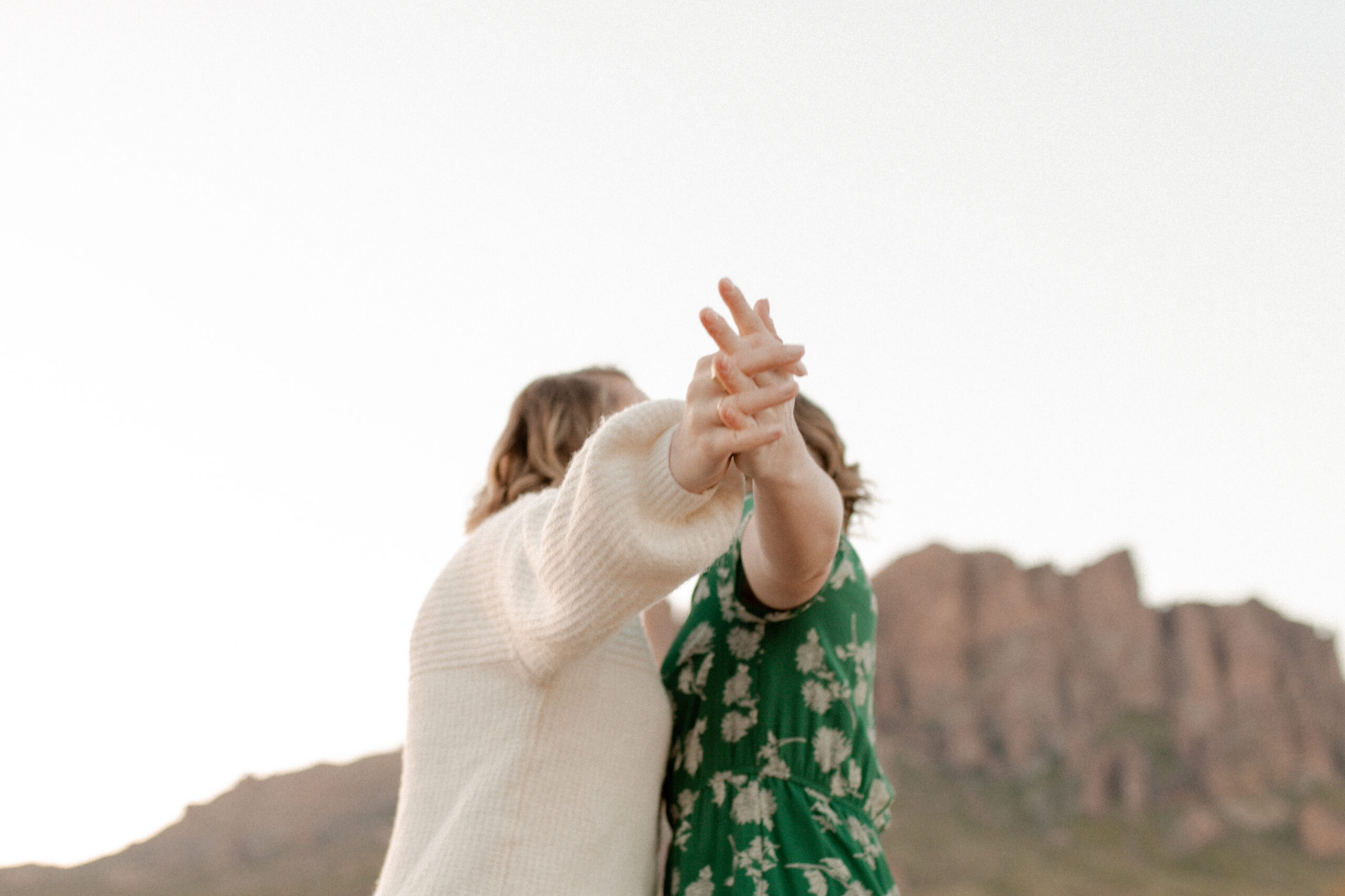 Two women pose in the superstition mountains for a documentary style engagement session